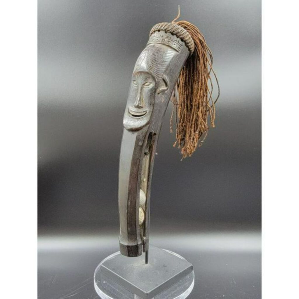 This Dyak Musket ball holder showing fearsome face demonstrates incorporation of Western weapons into non-Western art.